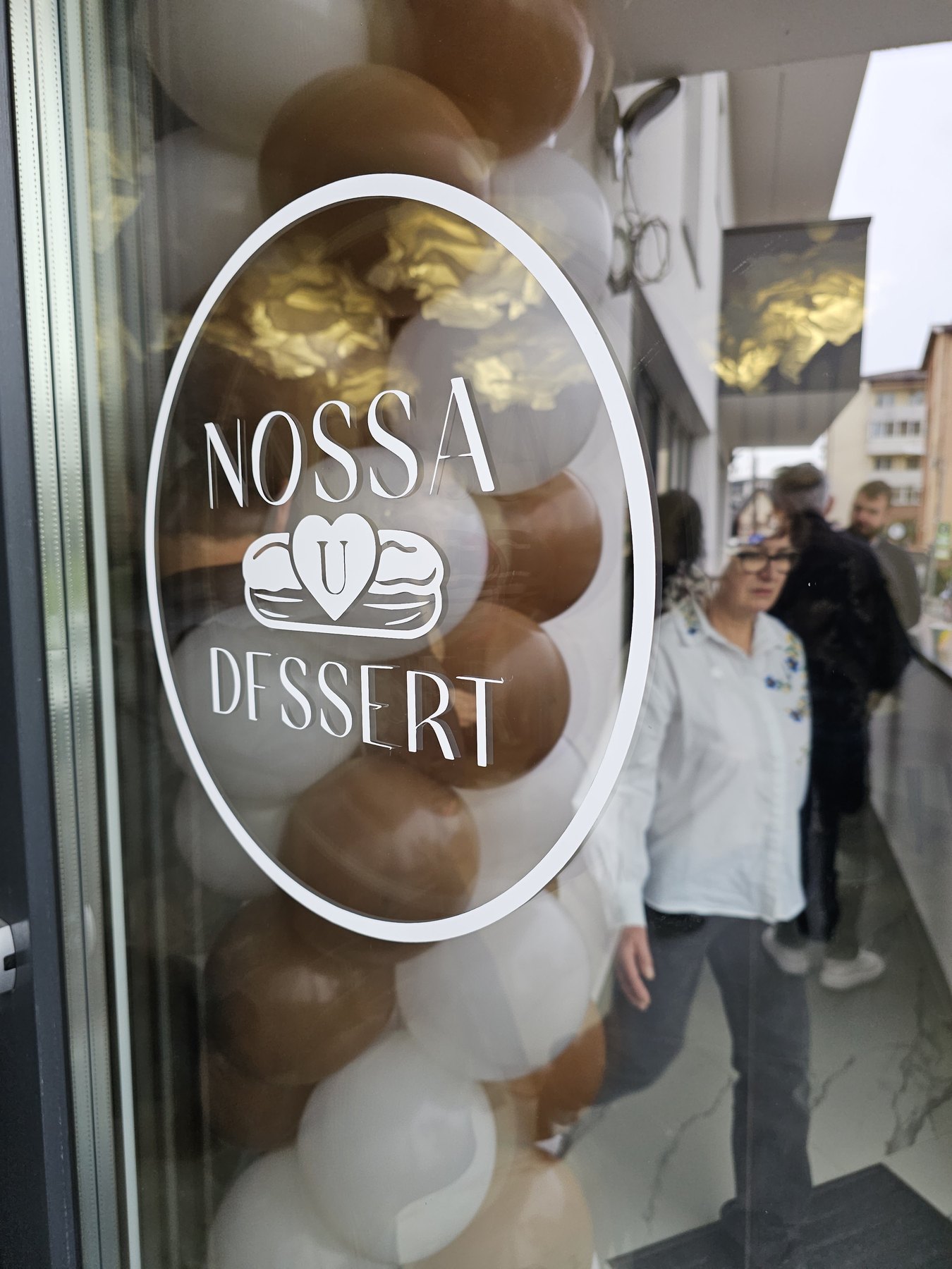 Vitrofania cu logo Nossa U Dessert, la stradă